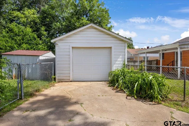 a view of a small house with wooden fence