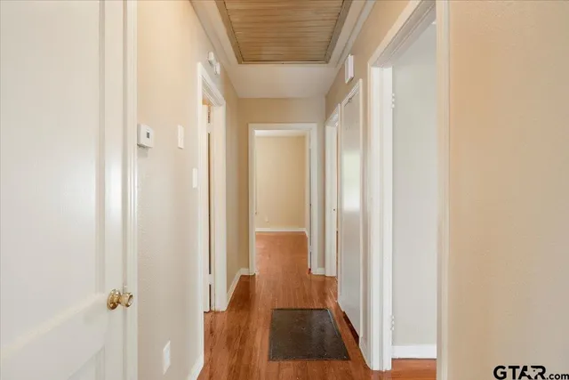 a view of a hallway with wooden floor and closet