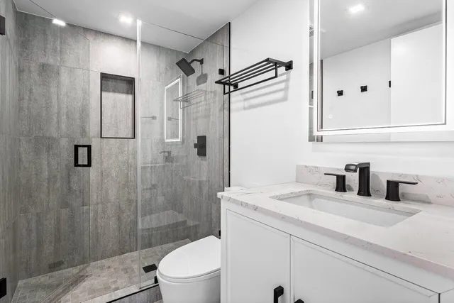 a bathroom with a sink toilet and shower