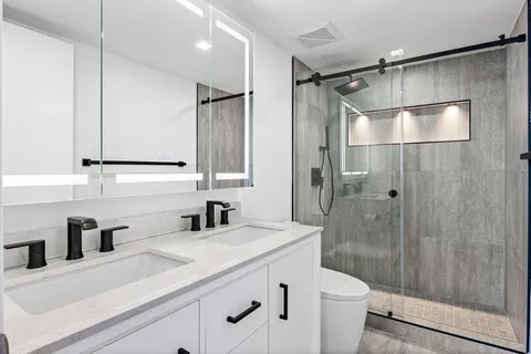 a bathroom with a sink a toilet and shower