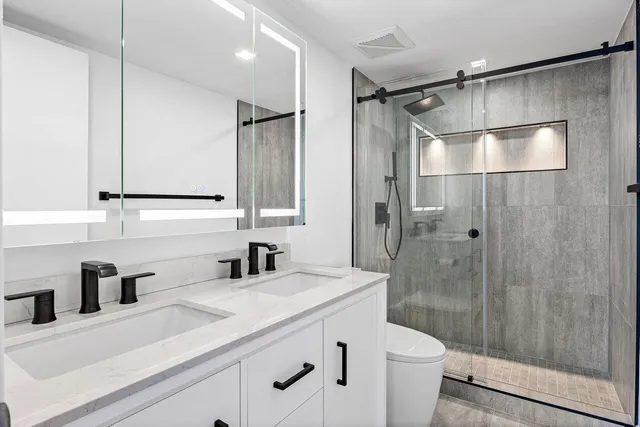 a bathroom with a sink a toilet and shower