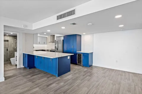 a kitchen with stainless steel appliances kitchen island granite countertop a large counter top and wooden floors