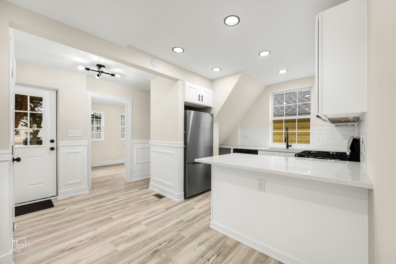 5147 Long Avenue Chicago, IL 60638 - Photo 4 of 17 a large white kitchen with a refrigerator a sink dishwasher and a stove with wooden floor