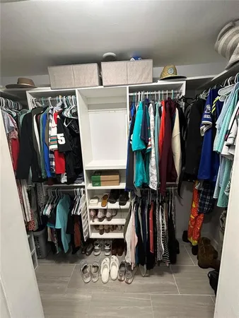 a view of walk in closet with clothes and shoes