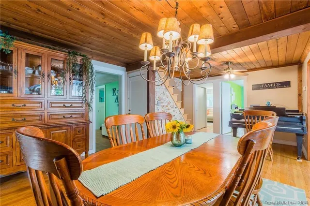 a view of a dining room with furniture a chandelier and wooden floor