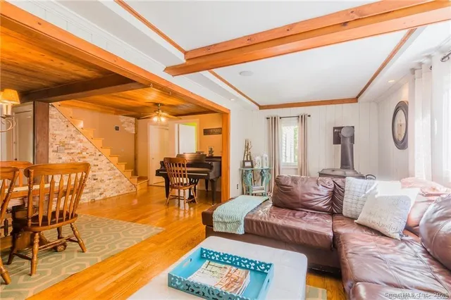 a living room with furniture a rug and a floor to ceiling window