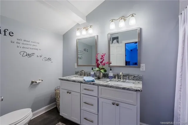 a bathroom with a granite countertop sink mirror and toilet