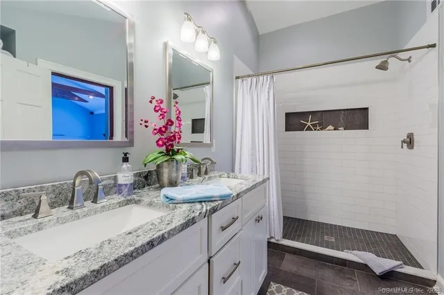 a bathroom with a granite countertop sink and a mirror