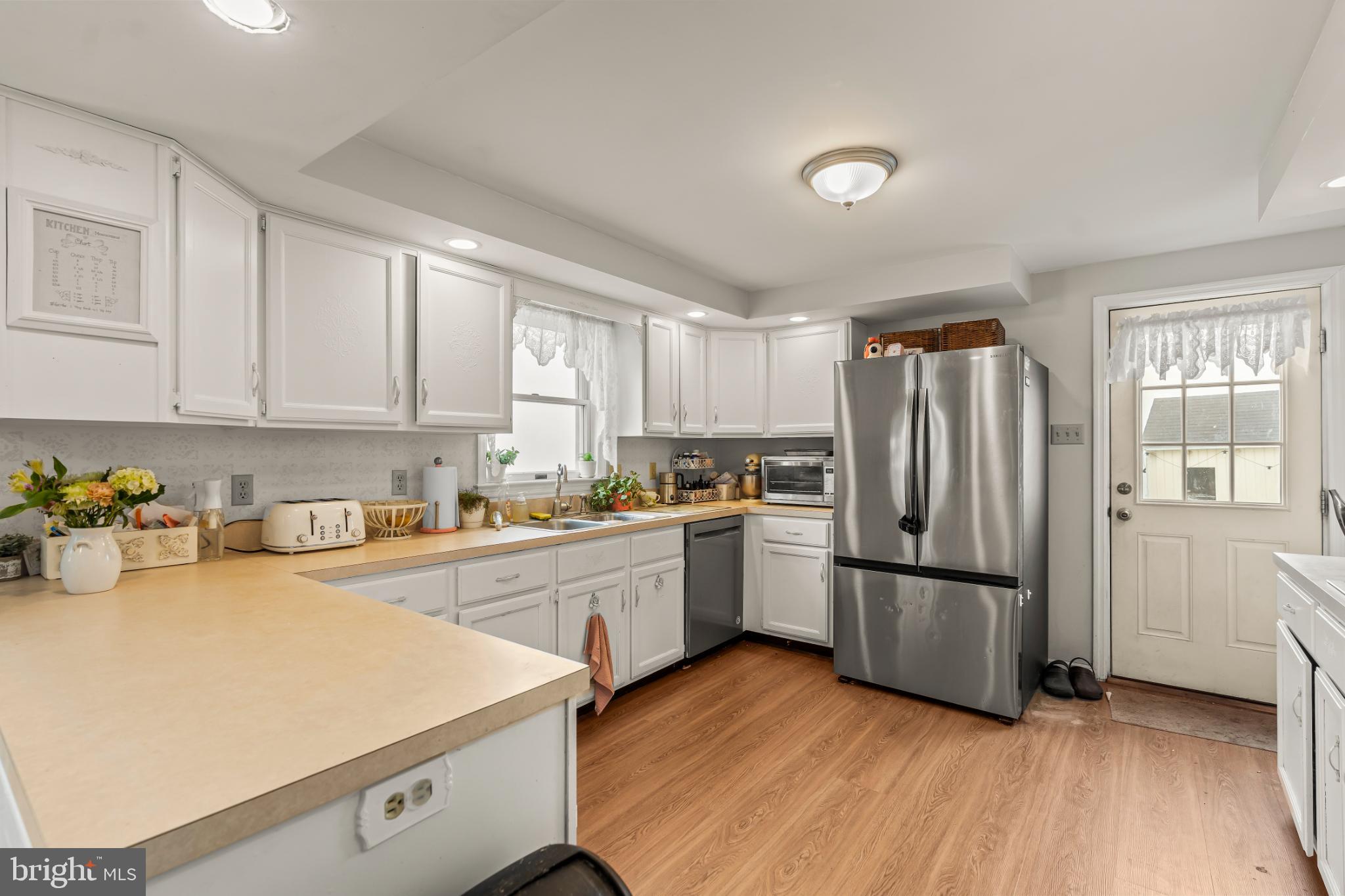 94 Tulip Court Falling Waters, WV 25419 - Photo 10 of 32 a kitchen with sink a refrigerator and white cabinets