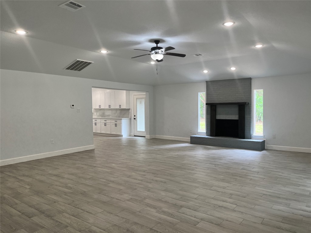 482 Rolling Livingston, TX 77351 - Photo 12 of 41 a view of an empty room with a fireplace and a ceiling fan