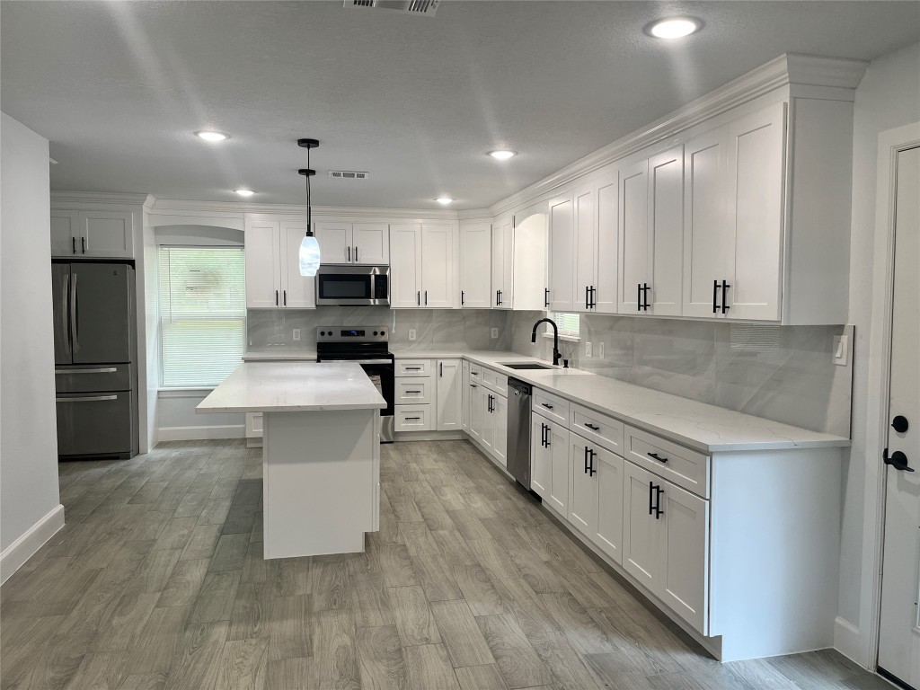 482 Rolling Livingston, TX 77351 - Photo 25 of 41 a kitchen with stainless steel appliances white cabinets a sink a stove a refrigerator and a center island