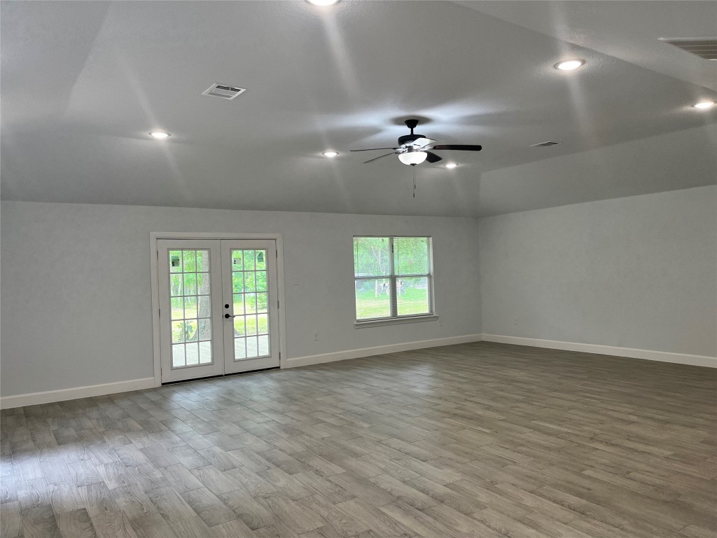 482 Rolling Livingston, TX 77351 - Photo 32 of 41 an empty room with wooden floor ceiling fan and windows