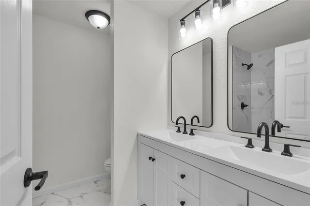a bathroom with double sink and a mirror