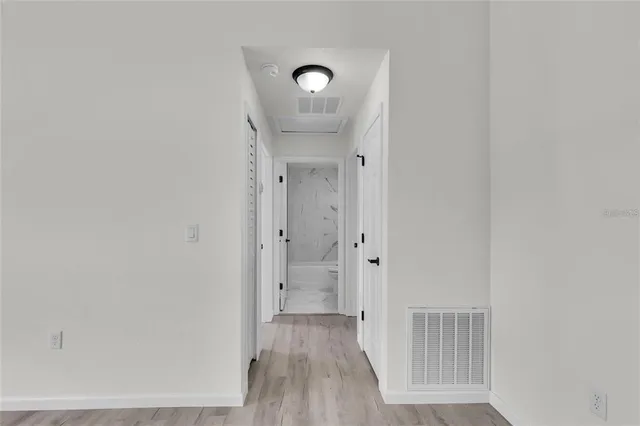 a view of a hallway with wooden floor
