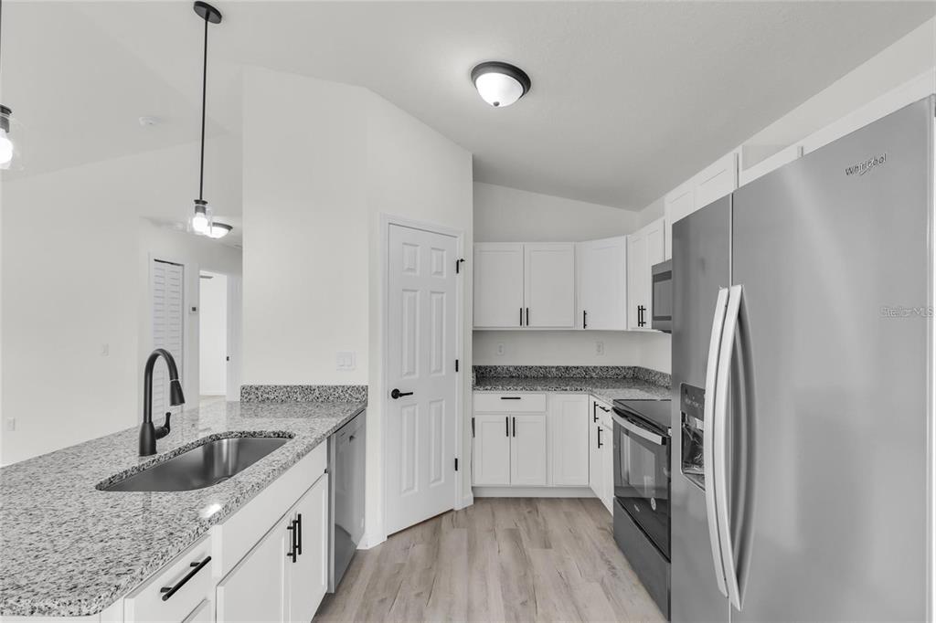 3401 Northeast 16th Court Ocala, FL 34479 - Photo 10 of 27 a kitchen with stainless steel appliances granite countertop a sink stove and refrigerator