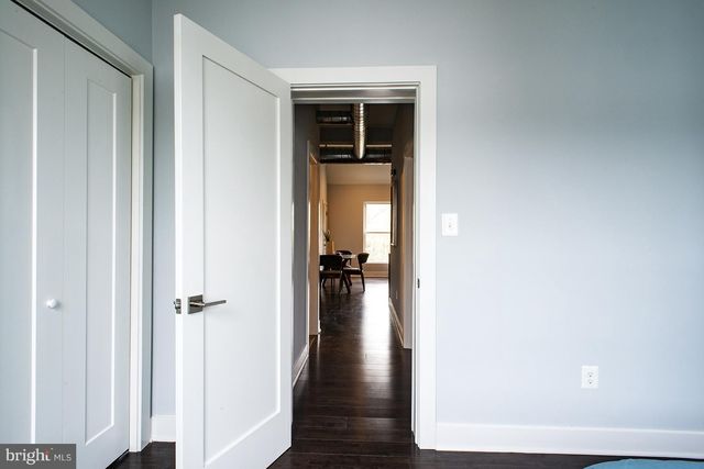 a view of a hallway with wooden floor and a living room