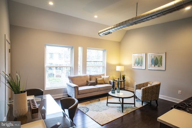 a living room with furniture a rug and a large window