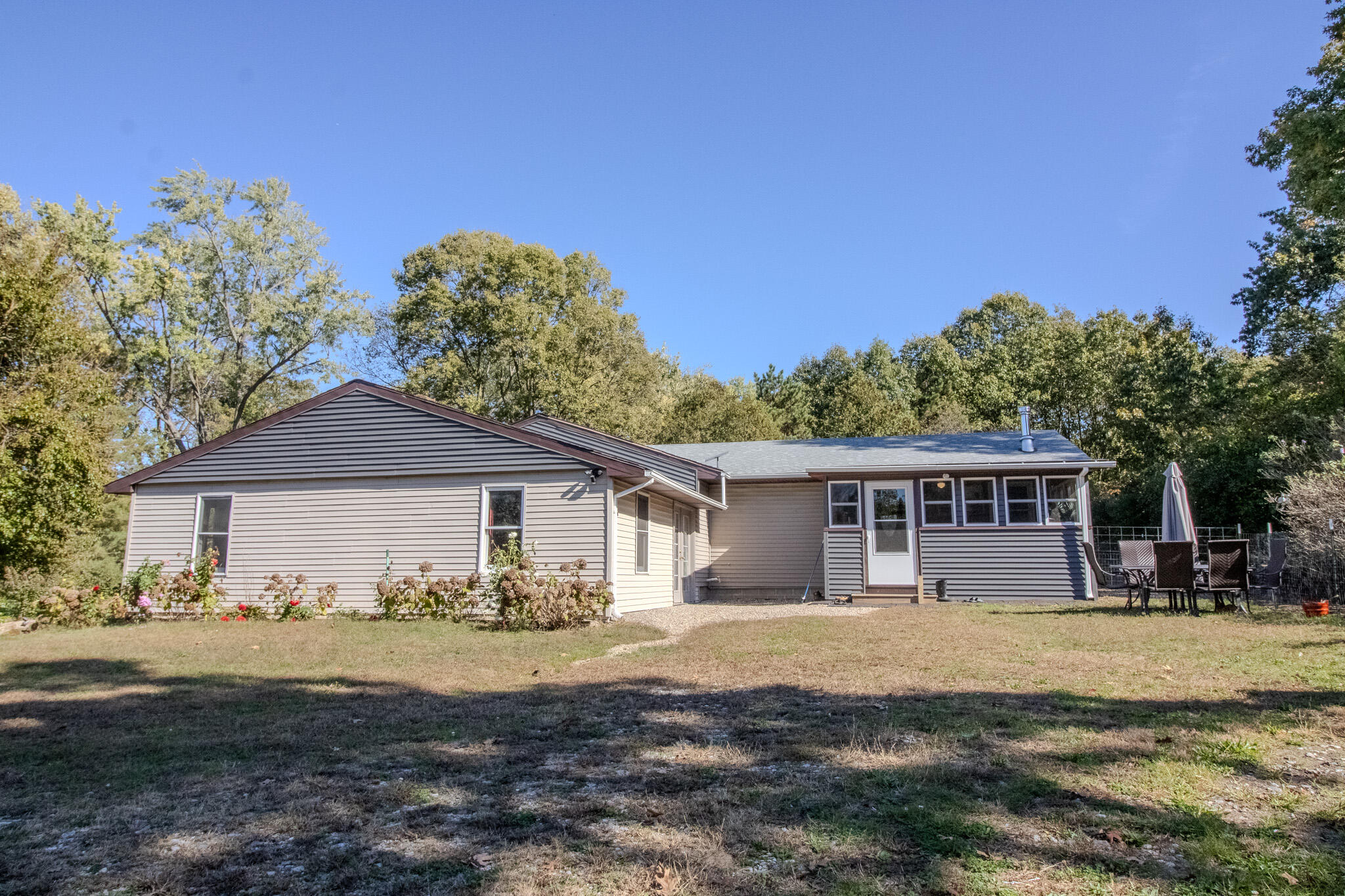 a front view of house with yard and trees in the background