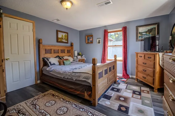 a bedroom with a bed and wooden floor