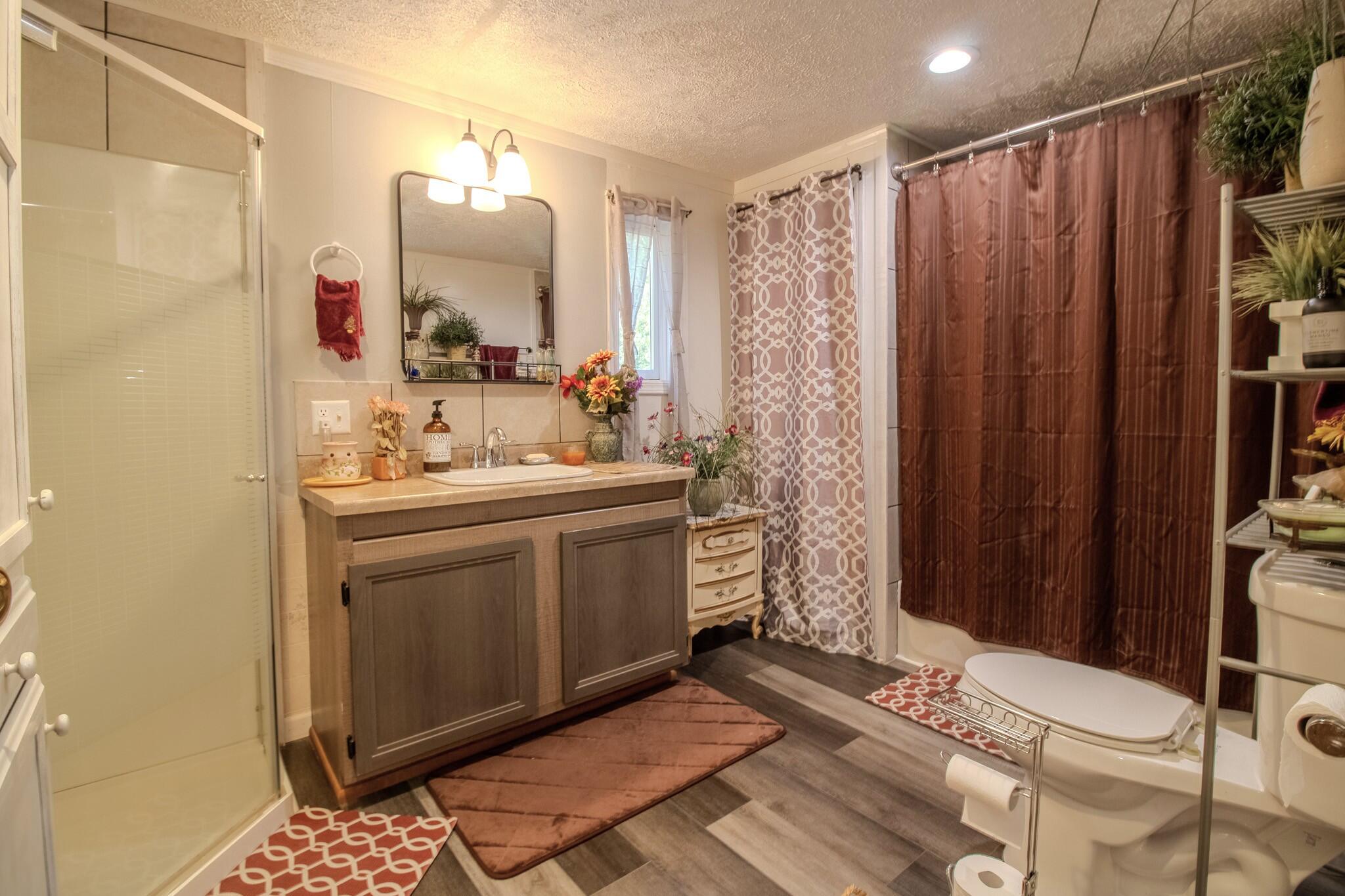 8845 East 200 South Knox, IN 46534 - Photo 10 of 24 a bathroom with a sink a mirror and a shower