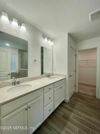 a spacious bathroom with double vanity and a mirror