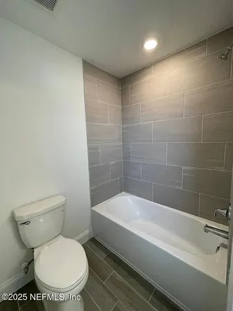 a bathroom with a toilet and bathtub