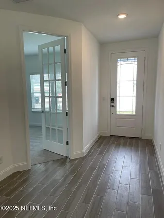 an empty room with wooden floor and windows