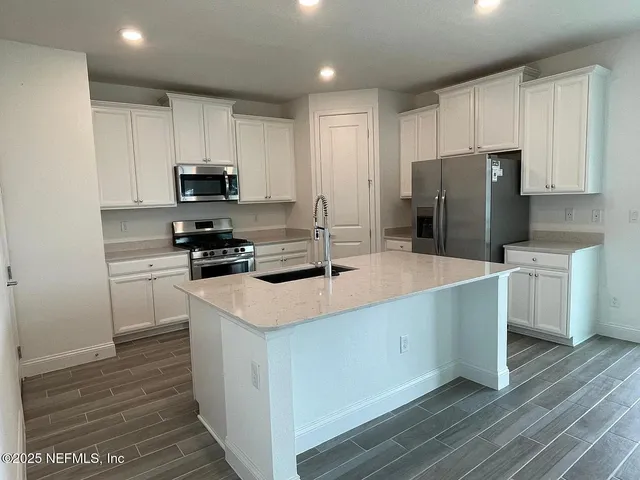 a kitchen with stainless steel appliances a refrigerator stove microwave and sink