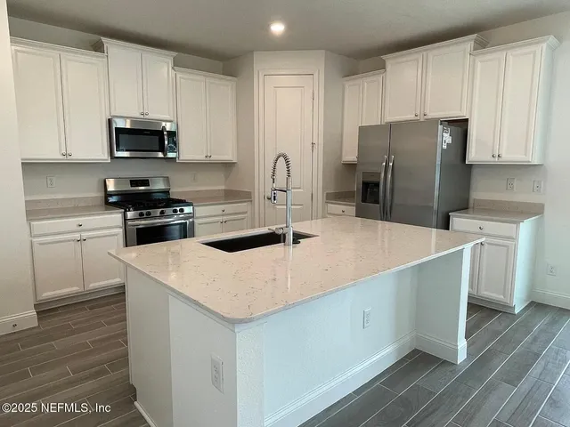 a kitchen with a sink a stove a refrigerator and cabinets