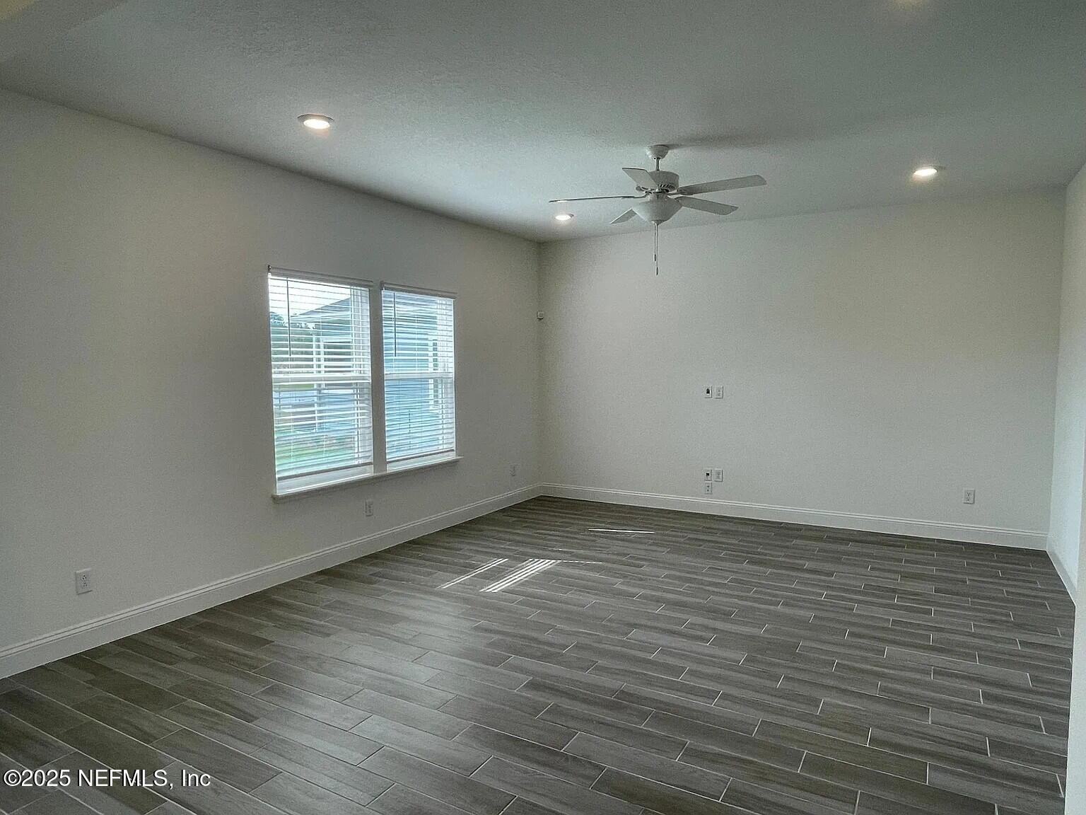 134 Varner Way St. Augustine, FL 32092 - Photo 8 of 30 an empty room with wooden floor ceiling fan and windows