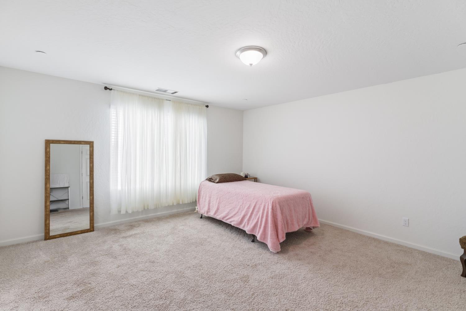 1617 North Filbert Avenue Fresno, CA 93727 - Photo 27 of 45 a spacious bedroom with a bed and a window