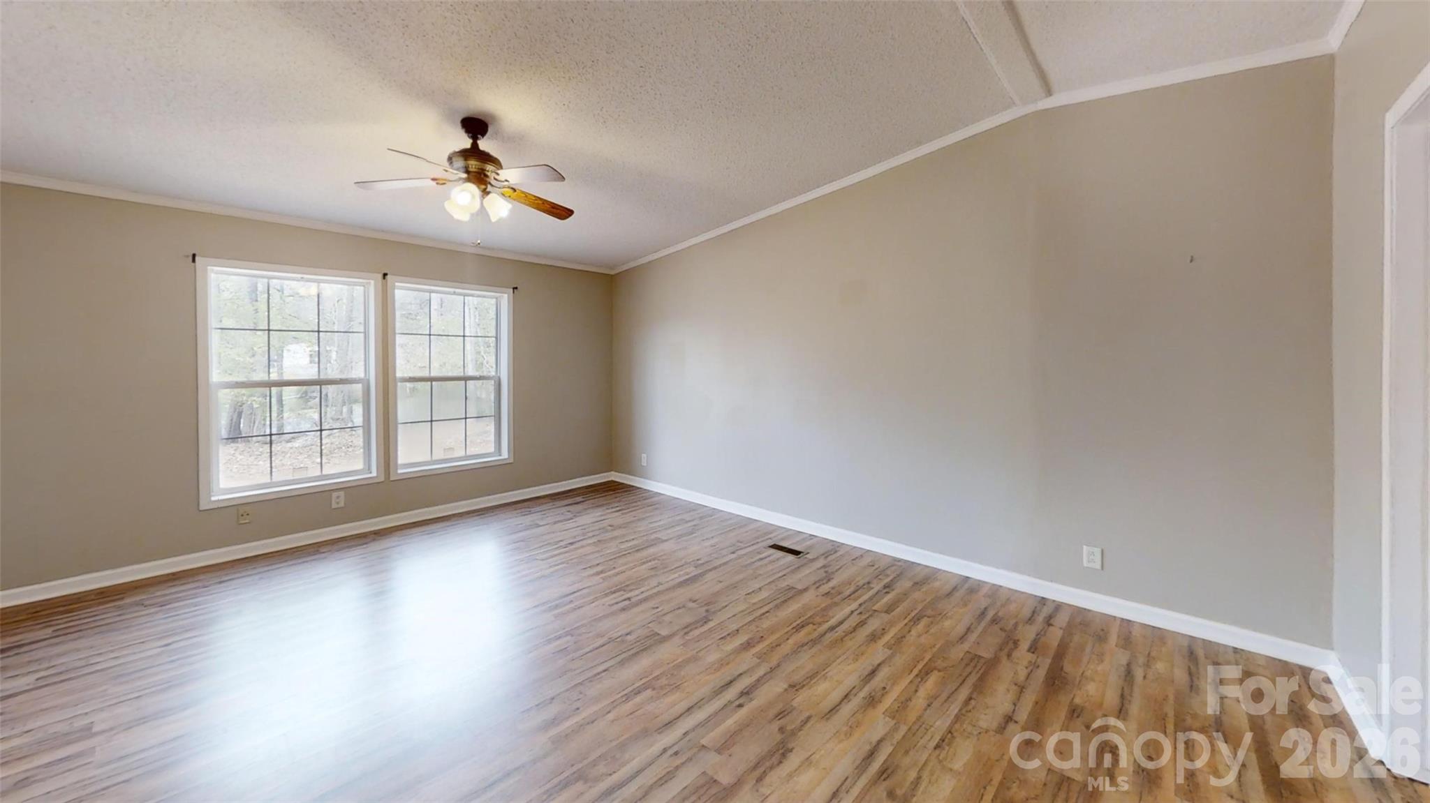 3441 Laboratory Road Lincolnton, NC 28092 - Photo 15 of 24 an empty room with wooden floor chandelier fan and windows