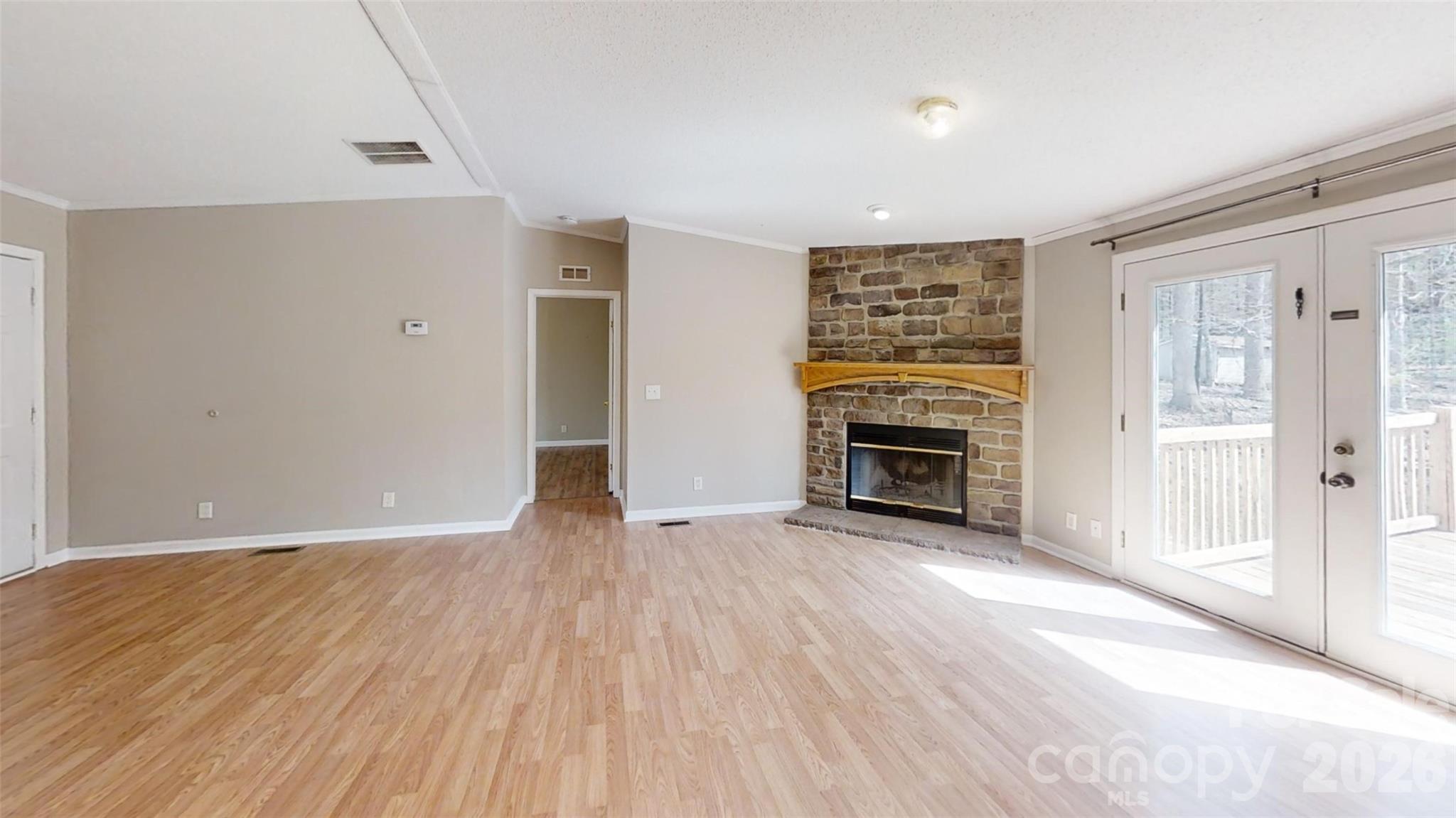 3441 Laboratory Road Lincolnton, NC 28092 - Photo 4 of 24 an empty room with wooden floor fireplace and windows