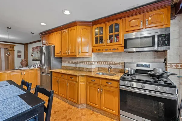 a kitchen with stainless steel appliances granite countertop a stove a sink and a microwave