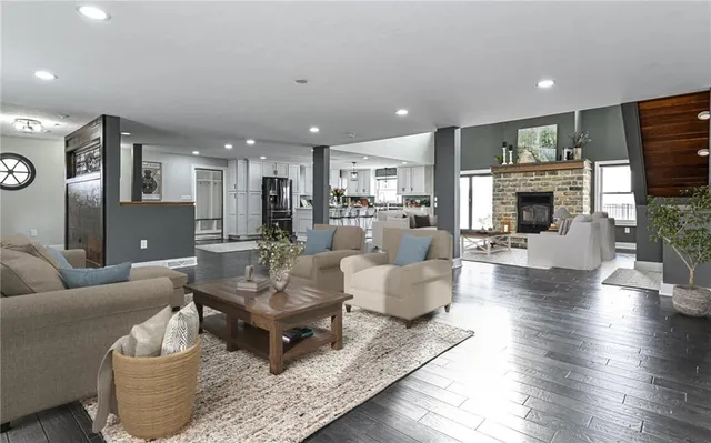 a living room with fireplace furniture and a view of kitchen