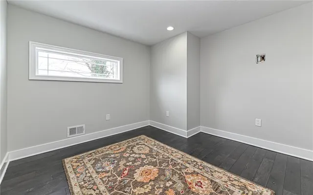 a bathroom with a granite countertop toilet sink and mirror