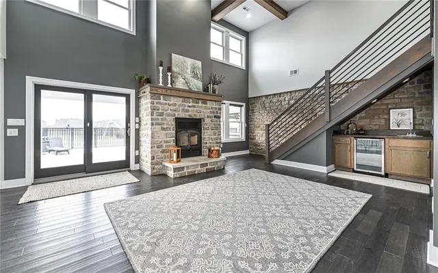 a view of a livingroom with wooden floor fireplace and windows