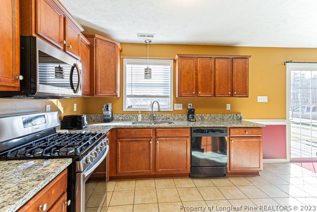 117 Ridgeview Drive Raeford, NC 28376 - Photo 12 of 31 a kitchen with stainless steel appliances granite countertop a stove a sink and a microwave