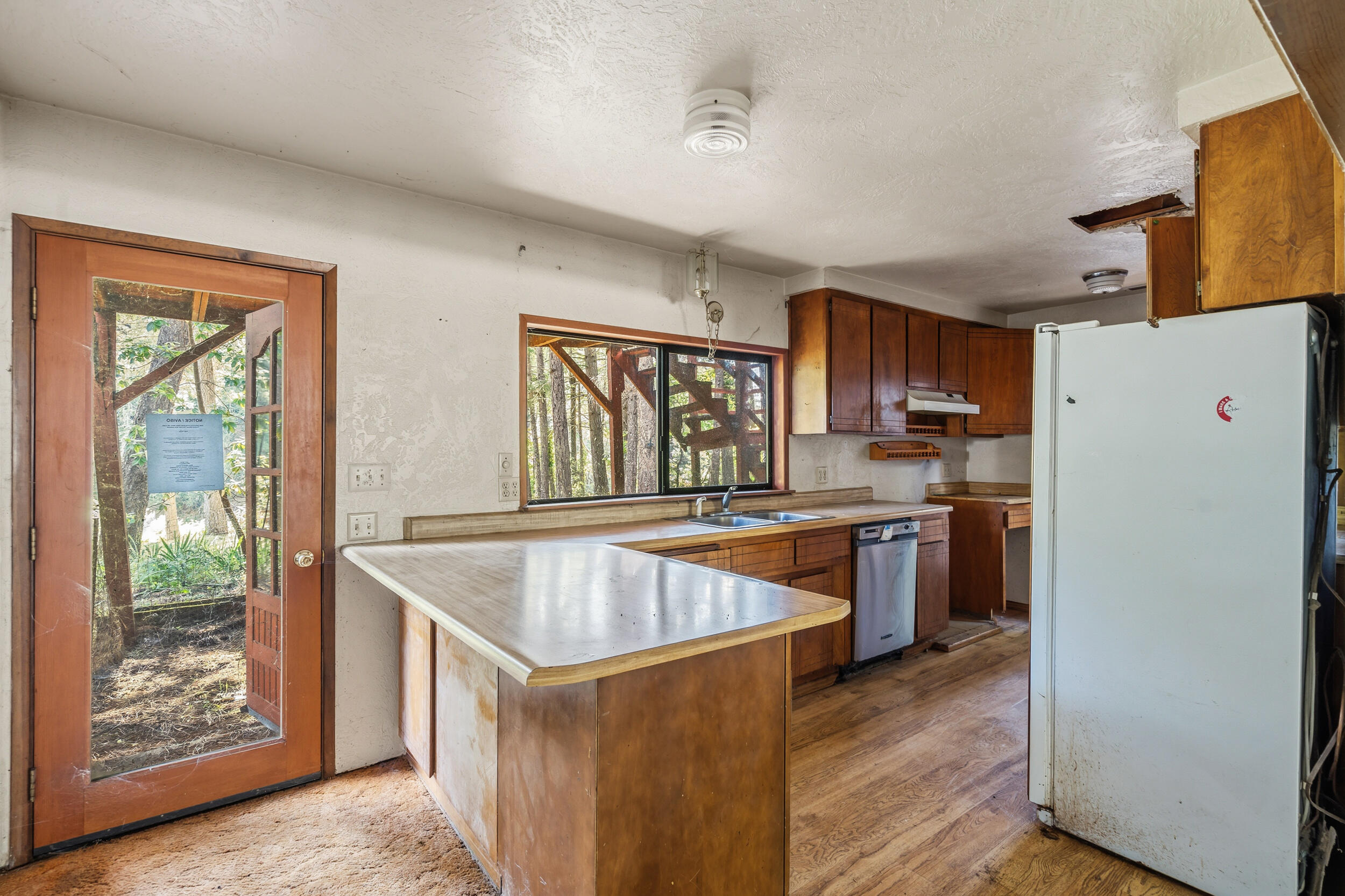 3300 West Evans Creek Road Rogue River, OR 97537 - Photo 7 of 21 a kitchen with a refrigerator a stove a sink dishwasher and wooden cabinets with wooden floor