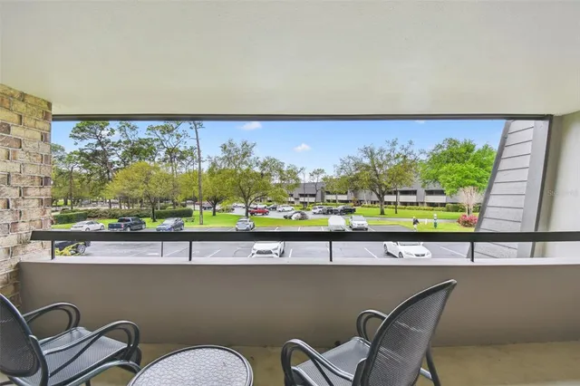 a view of a balcony with furniture and a floor to ceiling window