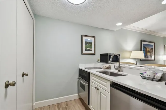 a kitchen with a sink cabinets and wooden floor