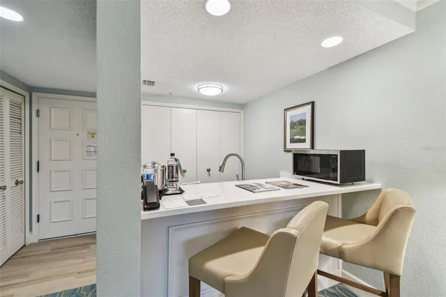 a dining room with a table chairs and a kitchen view