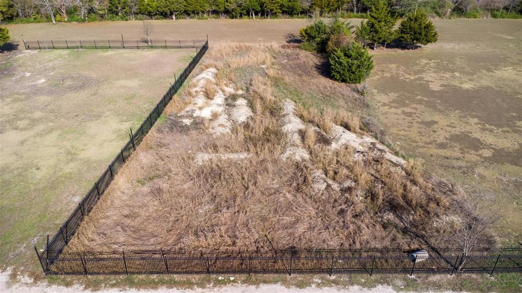 20 South Lancaster Hutchins Road Lancaster, TX 75146 - Photo 2 of 14 Expansive lot featuring a black chain-link fence, mature shrubbery, and natural terrain variations