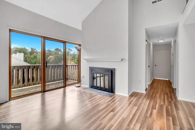 a view of empty room with wooden floor and fireplace