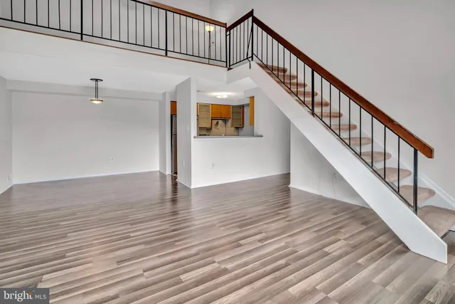 a view of staircase with wooden floor and white walls