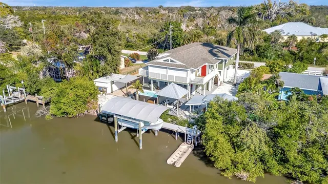 an aerial view of a house with swimming pool and lake view