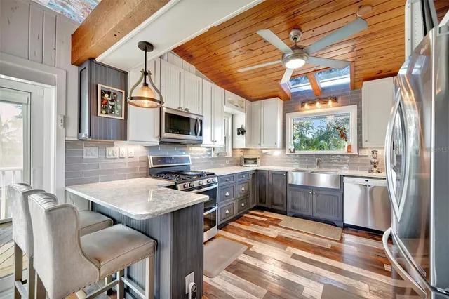 a kitchen with stainless steel appliances granite countertop a stove a sink and a refrigerator