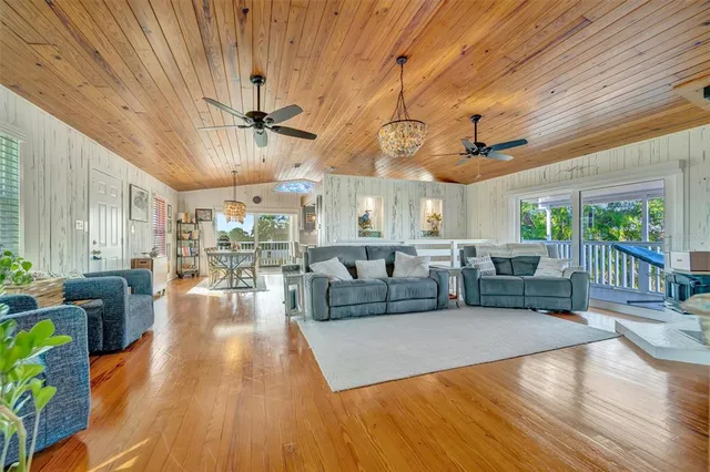 a living room with furniture a flat screen tv and kitchen view