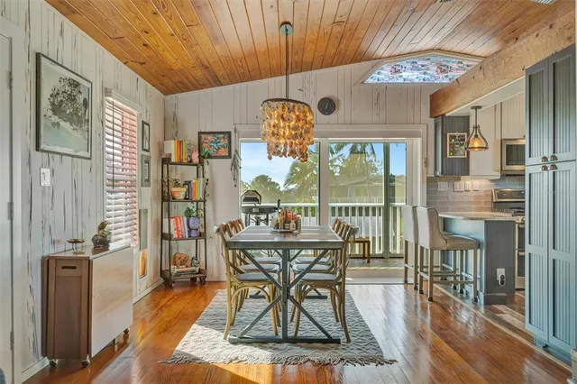 a kitchen with stainless steel appliances granite countertop a kitchen island hardwood floor sink stove dining table and chairs