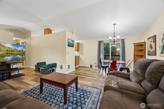 a living room with furniture a chandelier and a flat screen tv